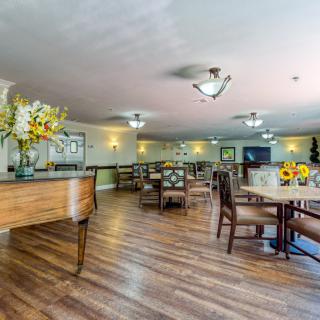 A spacious dining area with wooden flooring and elegant decor.