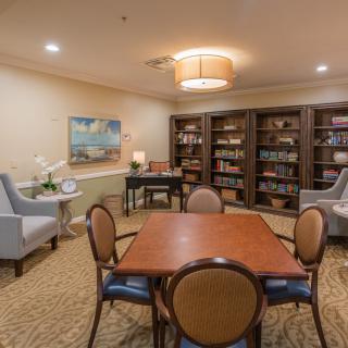 Cozy reading room with bookshelves and a central table for study or leisure.