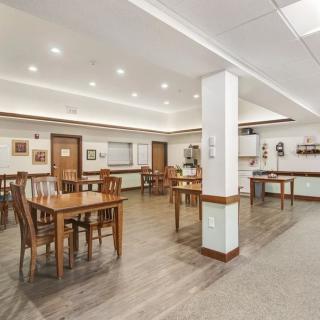 A well-lit dining area with wooden tables and chairs.