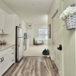 A modern kitchen interior with white cabinets and stainless steel appliances in a bright apartment.