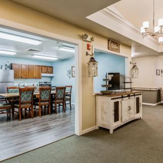 A view of a kitchen and dining area featuring wooden furniture and stylish lighting.
