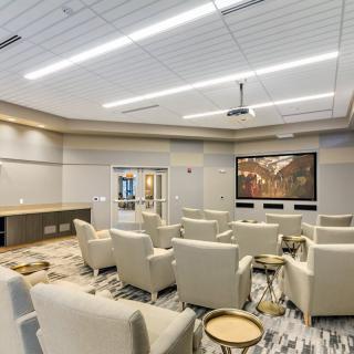 A modern home theater room with plush seating and a large screen.