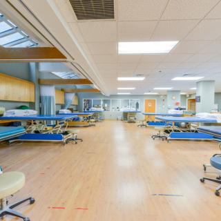 A spacious hospital treatment area with multiple beds and medical equipment.