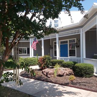 A house with a well-maintained front yard, featuring an American flag on the porch.