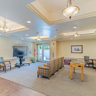 A spacious lounge area with comfortable seating, a television, and a foosball table.