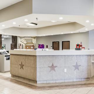 A modern hotel reception area featuring a stylish front desk and ambient lighting.