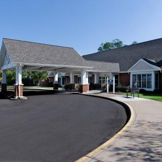 A residential building with a covered entrance and driveway.