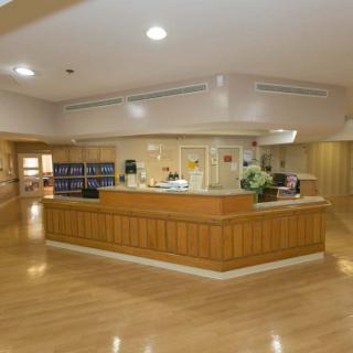 A well-lit hospital reception area with a central desk and clean surroundings.