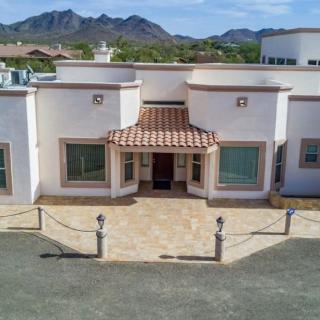 A modern residential house with a mountain backdrop and spacious driveway.