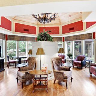 A beautifully designed living room with elegant furniture, a chandelier, and large windows providing ample natural light.