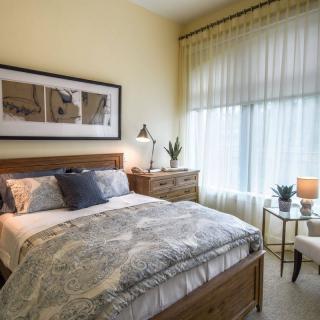 A cozy bedroom with a neatly made bed, soft lighting, and elegant decor.