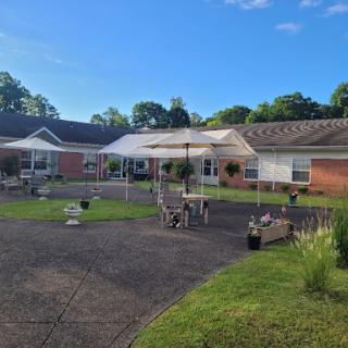 A sunny outdoor area featuring a garden and patio with seating.