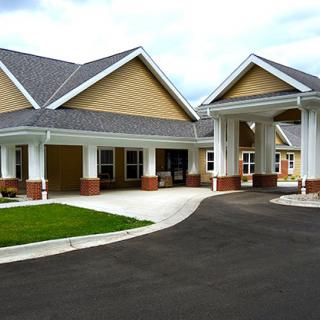 A modern residential building with a large driveway and prominent entrance.