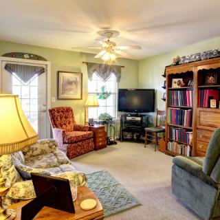 A cozy living room with comfortable seating, a bookshelf, and a TV.