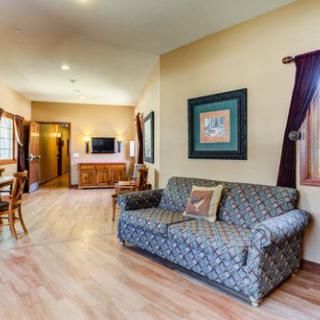 A cozy living room with a patterned sofa, wooden flooring, and a television.
