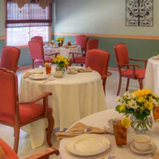 A cozy dining room with elegantly set tables and floral centerpieces.