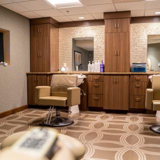 A modern barbershop interior with stylish chairs and mirrors.