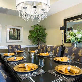 A beautifully set dining room table with a chandelier and elegant decor.