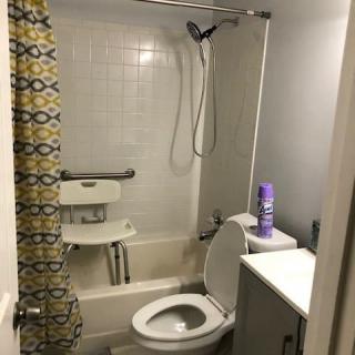 A small bathroom with a bathtub, shower, and toilet.