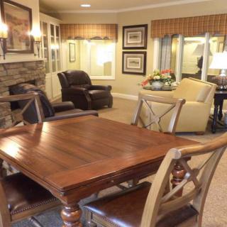 A cozy living room with a wooden table, comfortable armchairs, and a fireplace.