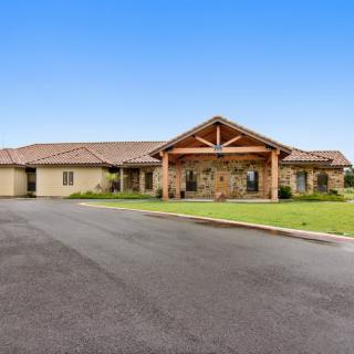 A single-story residential building with a well-maintained lawn and driveway.