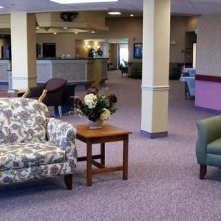 A spacious lobby with comfortable seating and a floral arrangement on a wooden table.