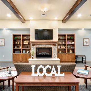 A cozy library interior featuring a fireplace and bookshelves, with 'LOCAL' decor as the focal point.