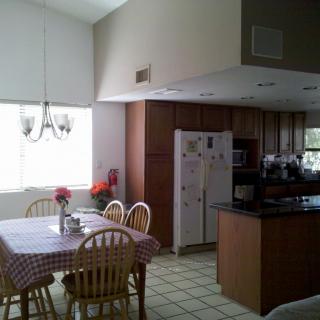 A well-lit kitchen and dining area with wooden cabinets and a table set for dining.