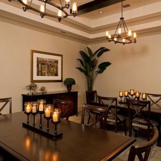 Elegant dining room with candles and chandeliers creating a warm ambiance.