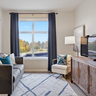 A modern living room with a large window, stylish furniture, and a cozy ambiance.