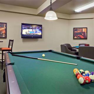 A cozy game room featuring a pool table and a television, perfect for relaxation and entertainment.