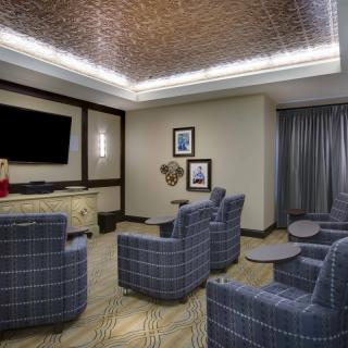 A modern lounge area with comfortable armchairs and a large television, ideal for meetings or relaxation.