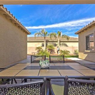 A serene patio view featuring a well-designed outdoor seating area surrounded by palm trees and a clear blue sky.