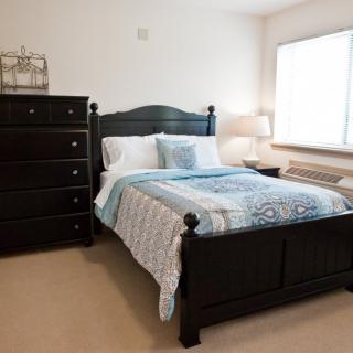 A cozy bedroom with a dark wooden bed and matching dresser.