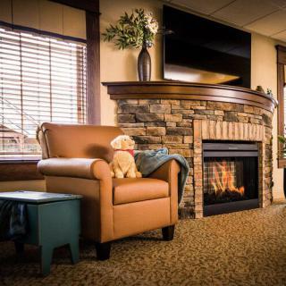 A cozy living room with a warm fireplace, an inviting armchair, and stylish decor.