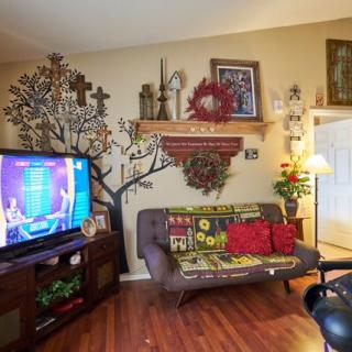 A cozy living room with vibrant decor and a TV turned on.