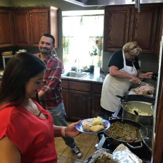 A group of people preparing and serving food in a home kitchen.