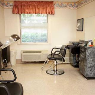 A neatly arranged hair salon with styling chairs and a work area.