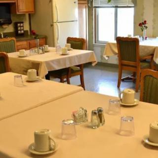 A neatly arranged dining room with tables set for a meal.