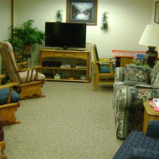 A cozy living room with various seating options and a television.