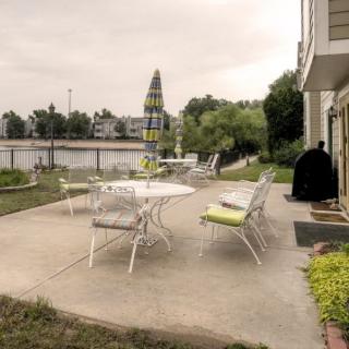 A tranquil patio setting with outdoor furniture overlooking a serene lake.