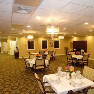 A cozy dining room with elegantly set tables and warm lighting.