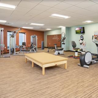 A modern indoor gym with various fitness equipment and exercise machines.