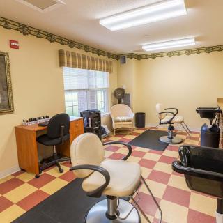 A well-lit salon interior with styling chairs and washbasins.