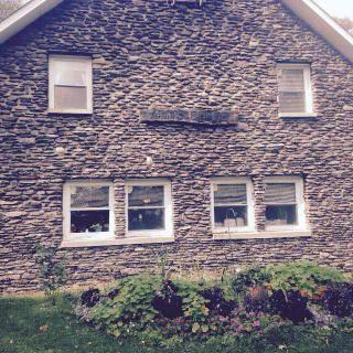 A charming stone house with a small garden in front.