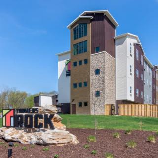 A modern apartment building with distinctive architecture and landscaped surroundings.