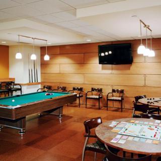 A cozy game room featuring a pool table, board games, and a mounted television.