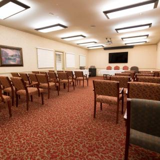 A well-organized conference room with rows of chairs facing a TV for presentations.