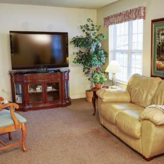 A cozy living room with a television, sofa, and decorative elements.
