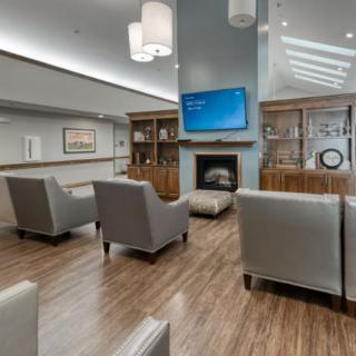 A modern lounge area featuring comfortable seating, a fireplace, and a mounted television.